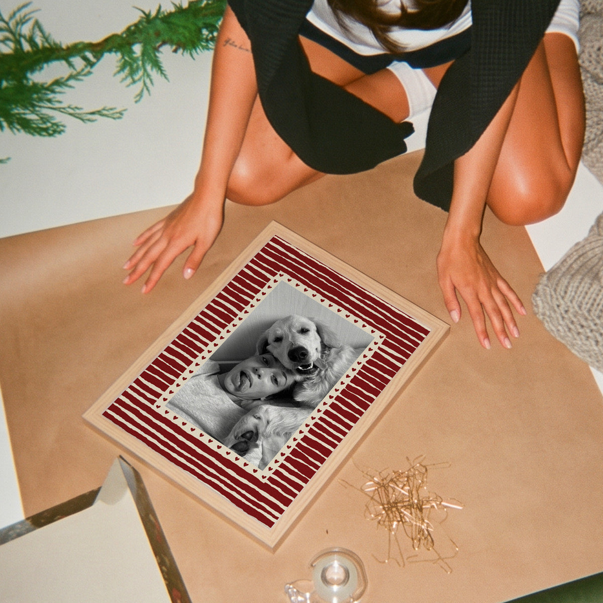 Hearts custom pet photo print in Cherry Red, in a light birch wood frame, laid on brown paper, with an example photo